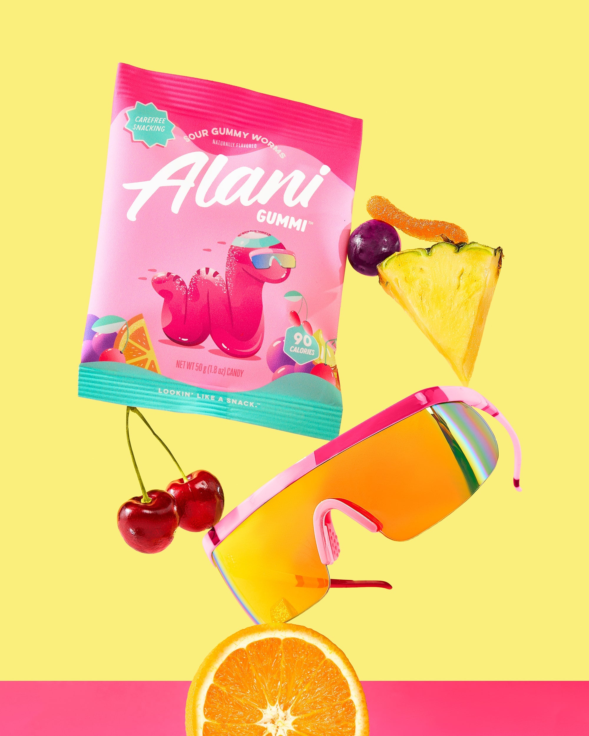 A variety of fruit displayed next to fashion glasses with Sour Gummy Worms flavor.